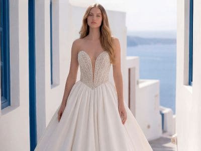 Elegantes Hochzeitskleid mit Herz-Ausschnitt vor Meerblick in Santorini.