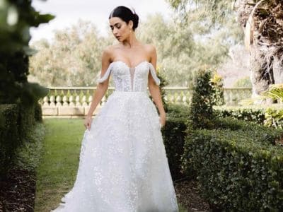 Elegantes Brautkleid im Garten mit off-Shoulder-Design und Spitze.