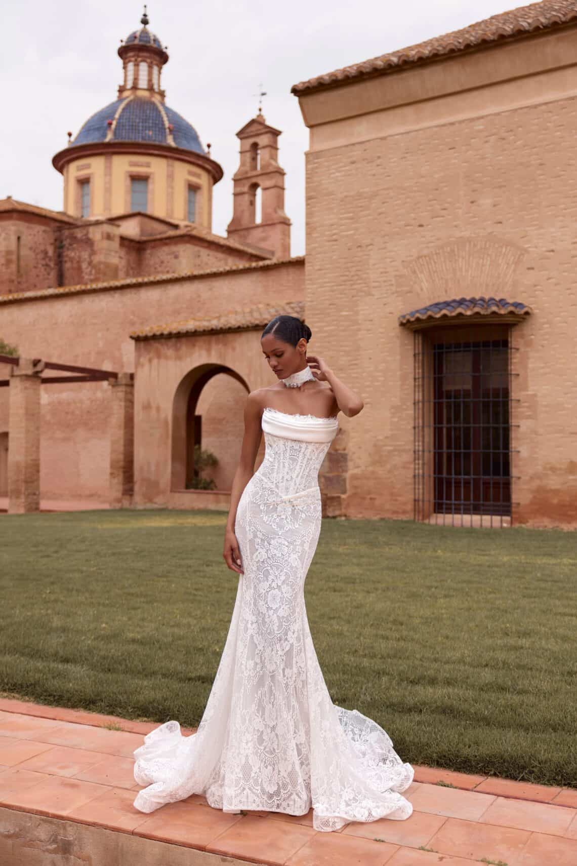 Braut in elegantes Spitzenkleid vor historischer Kulisse bei Lusandra.