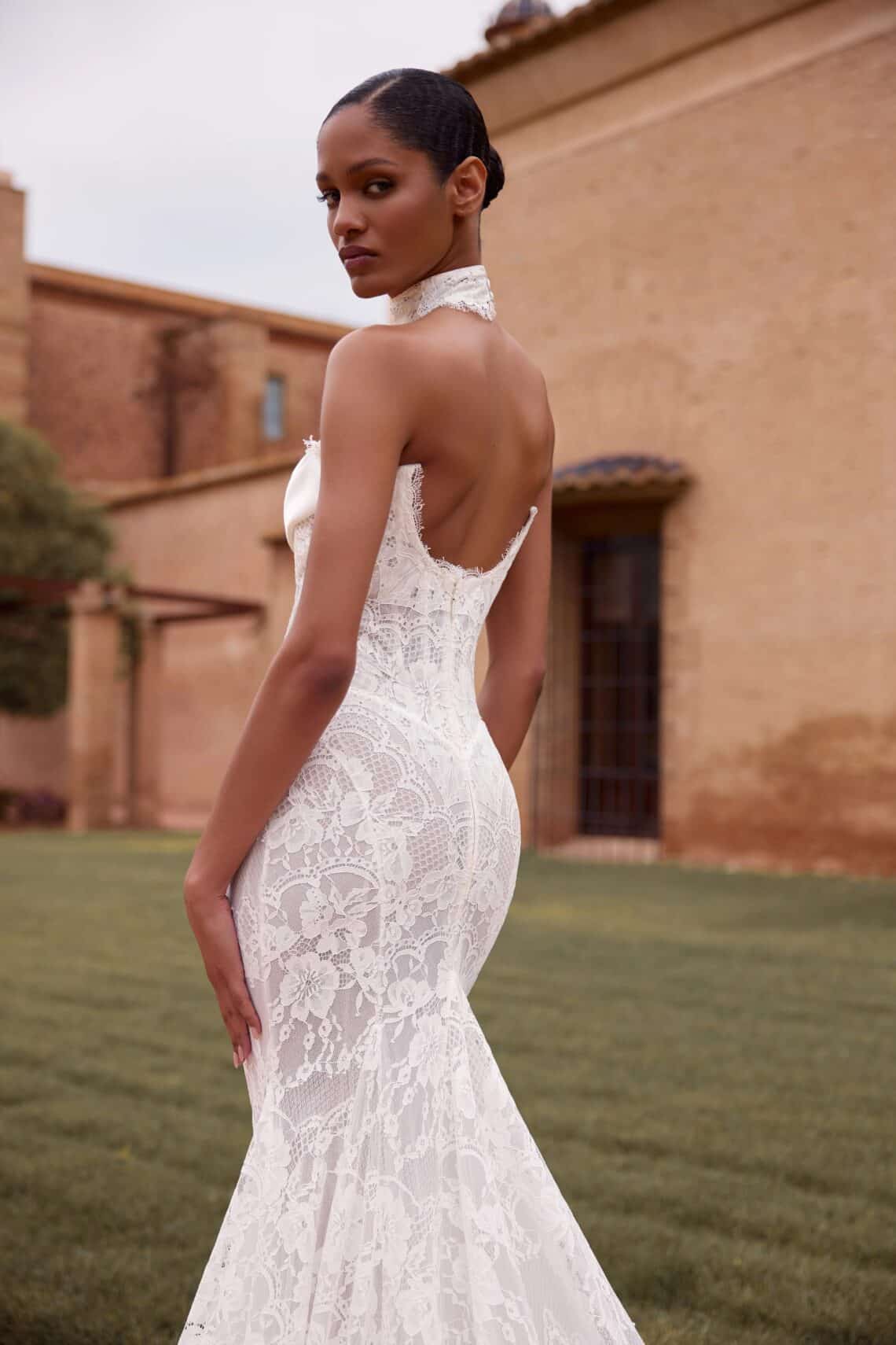 Elegantes Hochzeitskleid mit Spitze und offener Rücken, Braut im Garten.