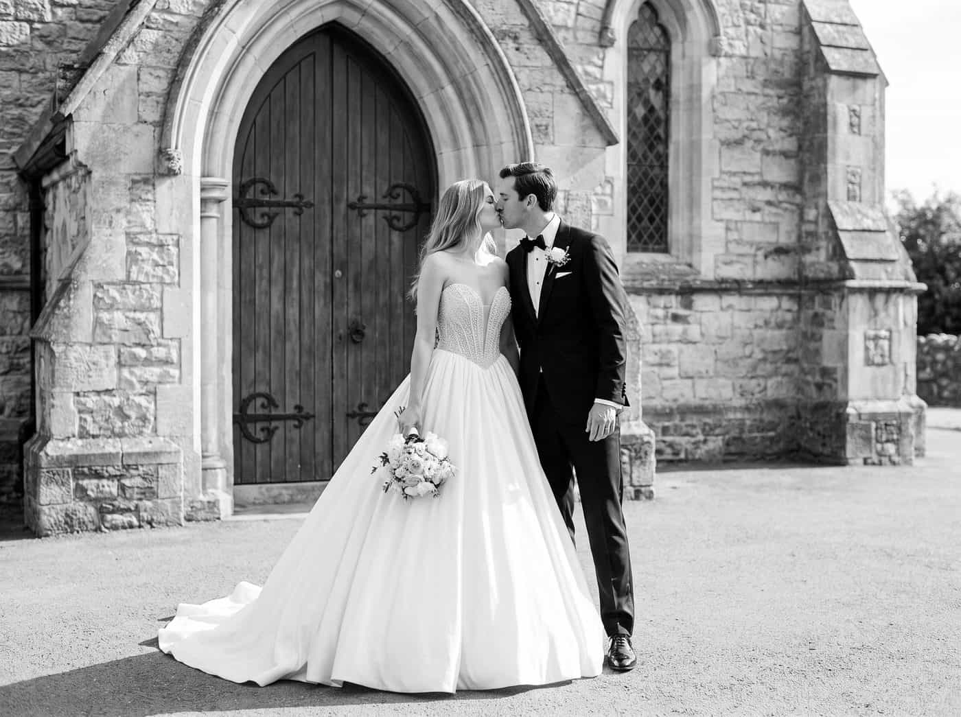 Braut und Bräutigam vor Kirche bei ihrer Hochzeit.